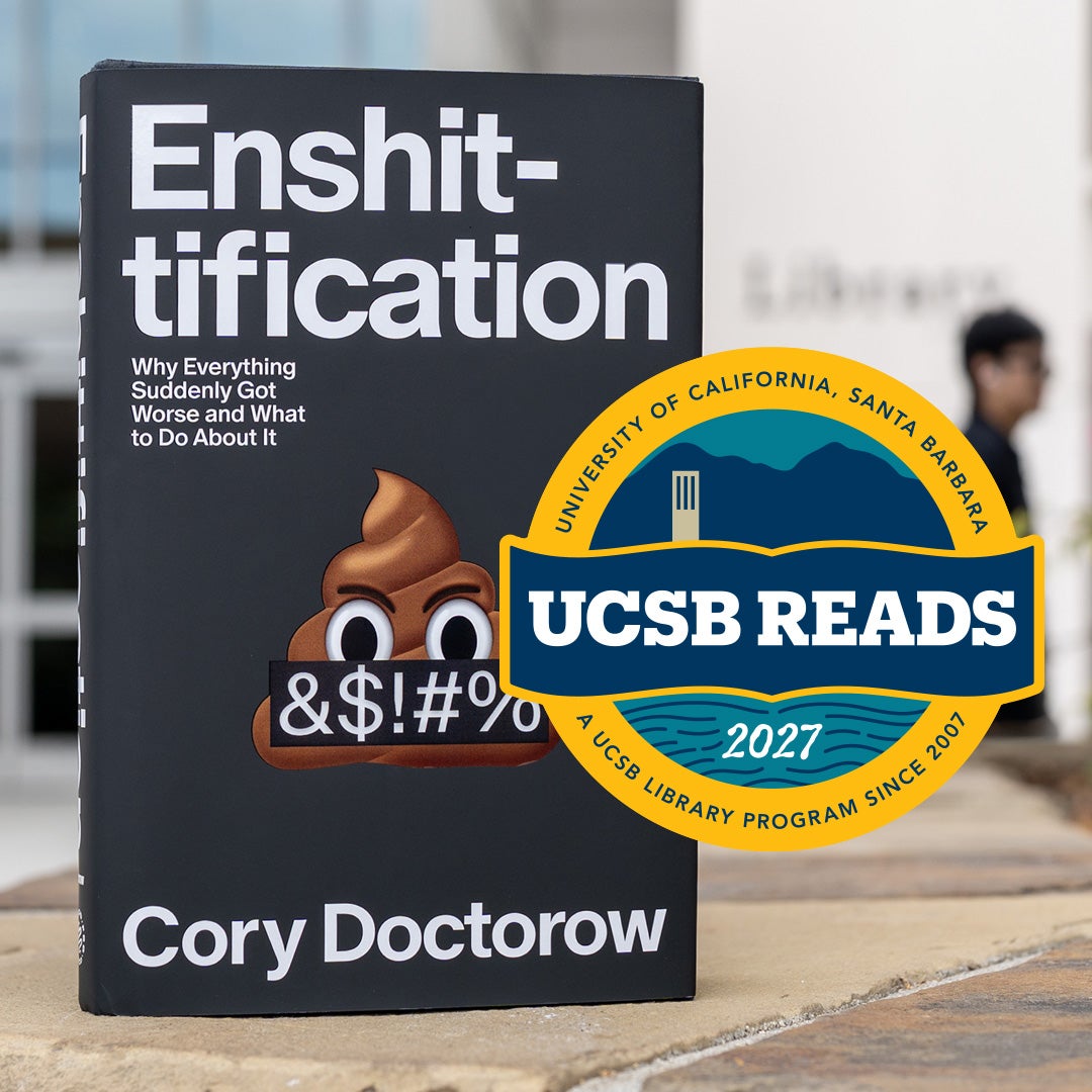 Copy of "Enshittification" by Cory Doctorow with the UCSB Reads 2027 badge in front of UCSB Library's Paseo West entrance.