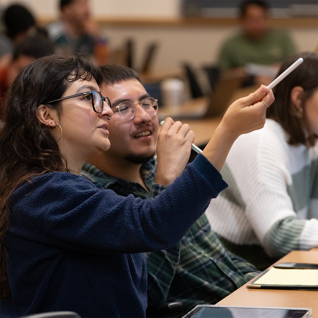 Two UCSB environmental data science students gesturing with styluses during a classroom discussion.