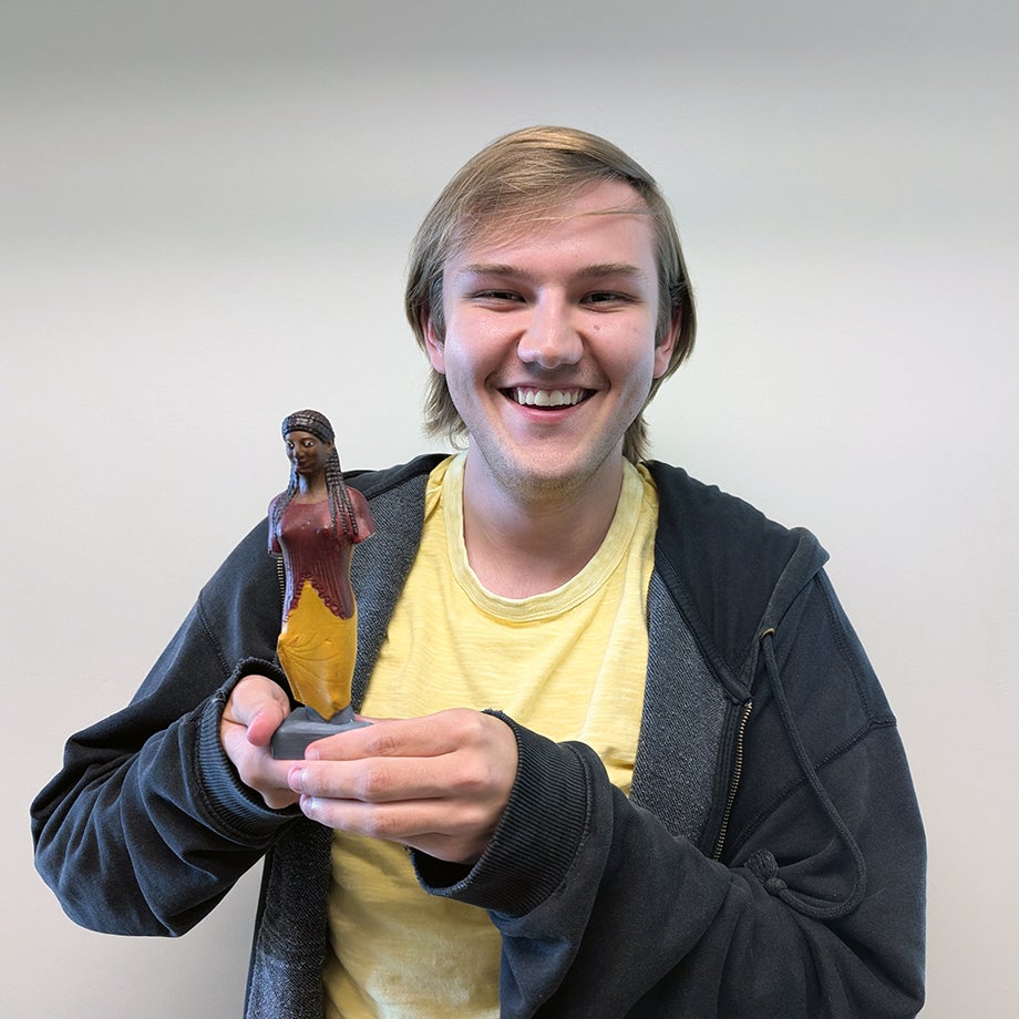 Student in Prof. Lamar's class holding 3D printed replica of ancient Greek artifact