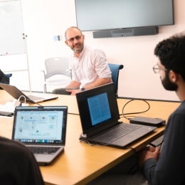 A professor sitting at a table with students
