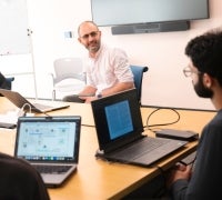 A professor sitting at a table with students